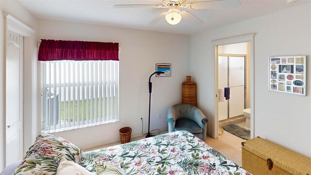 carpeted bedroom featuring ensuite bath and ceiling fan