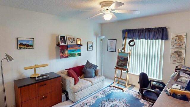 living room featuring a textured ceiling, ceiling fan, and light carpet