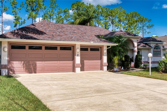 view of front of house with a shingled roof, concrete driveway, a garage, and stucco siding