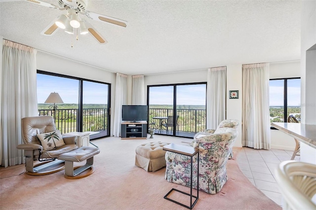 living room with light carpet, a textured ceiling, a healthy amount of sunlight, and ceiling fan