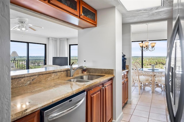 kitchen featuring pendant lighting, ceiling fan with notable chandelier, stainless steel appliances, sink, and light tile patterned flooring