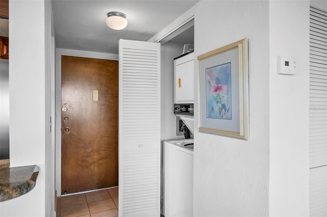 washroom with light tile patterned floors and stacked washer / dryer