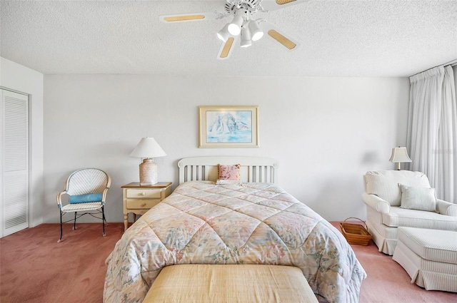 bedroom featuring a textured ceiling, light colored carpet, and ceiling fan