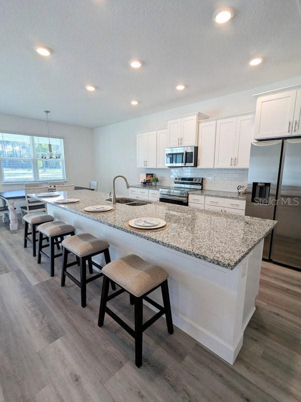 kitchen with a large island, stainless steel appliances, and white cabinetry