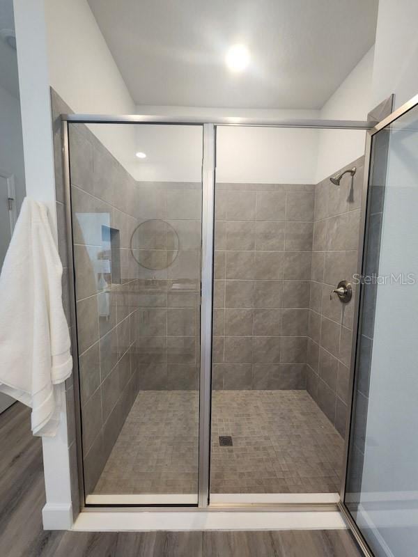 bathroom featuring hardwood / wood-style flooring and a shower with door