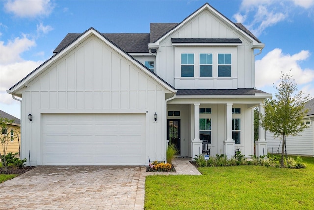 view of front of home with a front lawn, a garage, and a porch