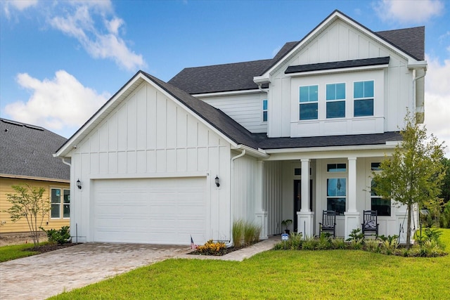 view of front of house with a garage, a front yard, and a porch