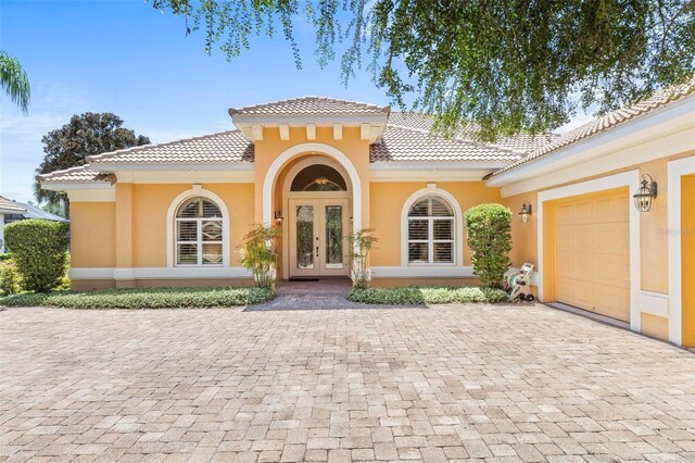 view of front of home with a garage and french doors