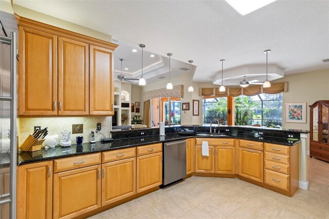 kitchen with pendant lighting, kitchen peninsula, and dark stone counters