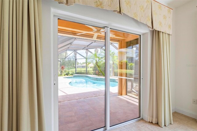 doorway featuring ceiling fan and light tile patterned floors