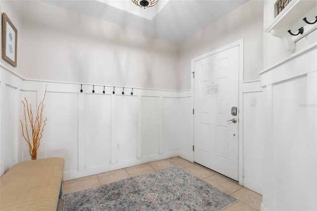 interior space with a textured ceiling and light tile patterned flooring