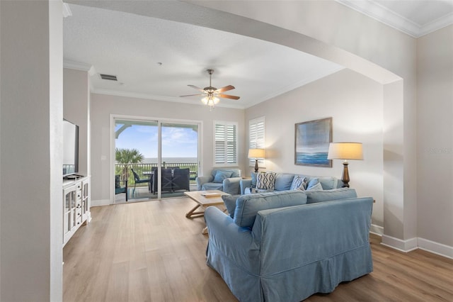 living room featuring ceiling fan, crown molding, and light hardwood / wood-style floors