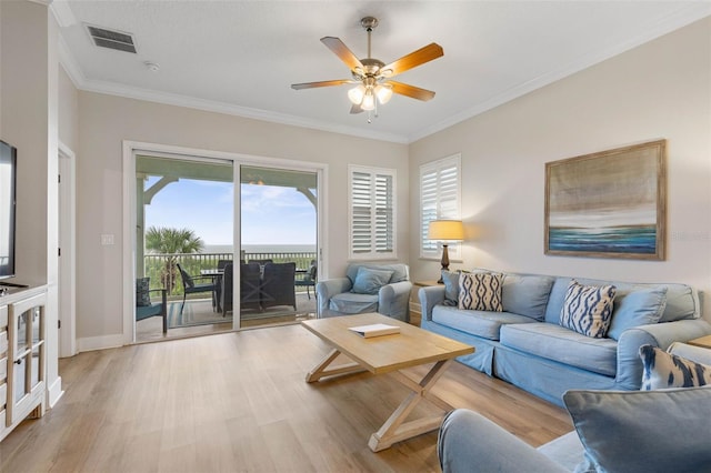 living room with light hardwood / wood-style flooring, ceiling fan, and crown molding