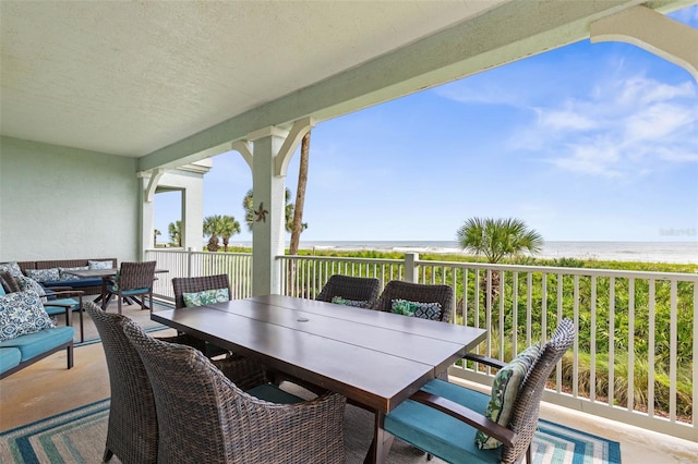 view of patio featuring a view of the beach, a water view, and an outdoor living space