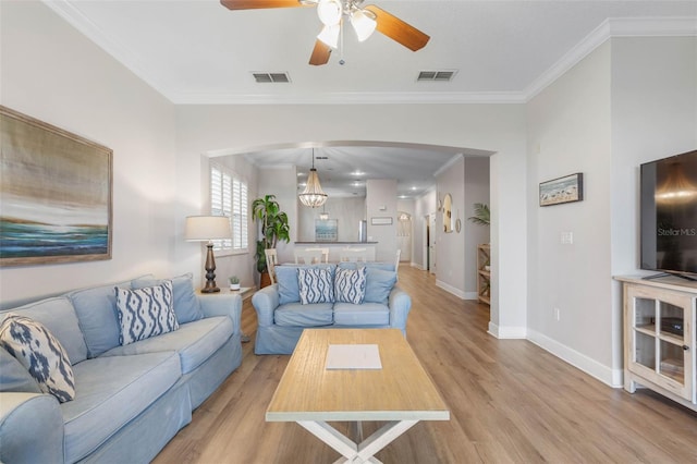 living room with light hardwood / wood-style flooring, ceiling fan, and crown molding