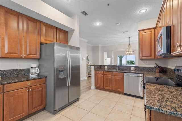 kitchen featuring dark stone counters, stainless steel appliances, a textured ceiling, and sink