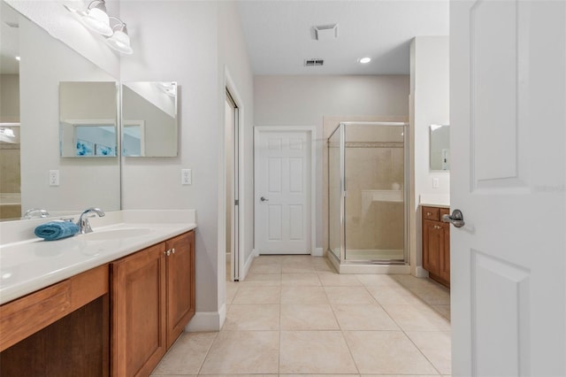 bathroom with tile patterned flooring, a shower with door, and vanity