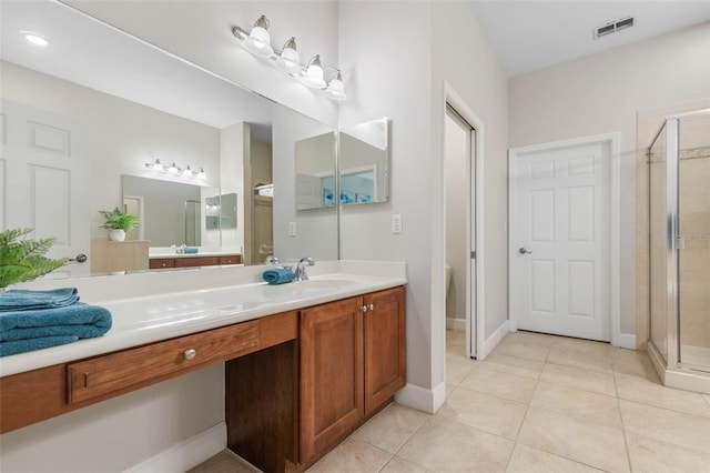 bathroom featuring vanity, toilet, an enclosed shower, and tile patterned floors