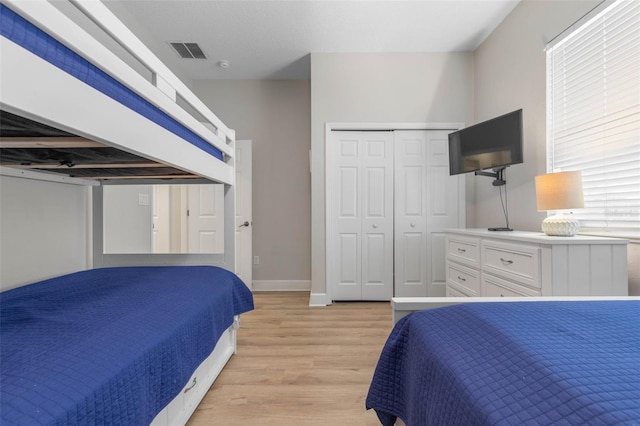 bedroom with light wood-type flooring and a closet