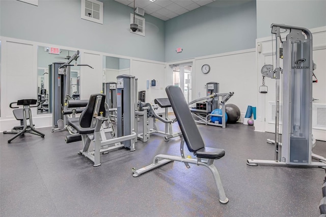 gym with a paneled ceiling and a high ceiling