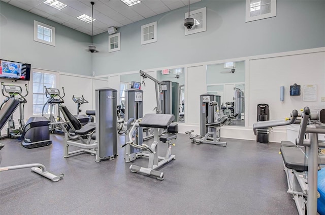 gym featuring a high ceiling and a drop ceiling