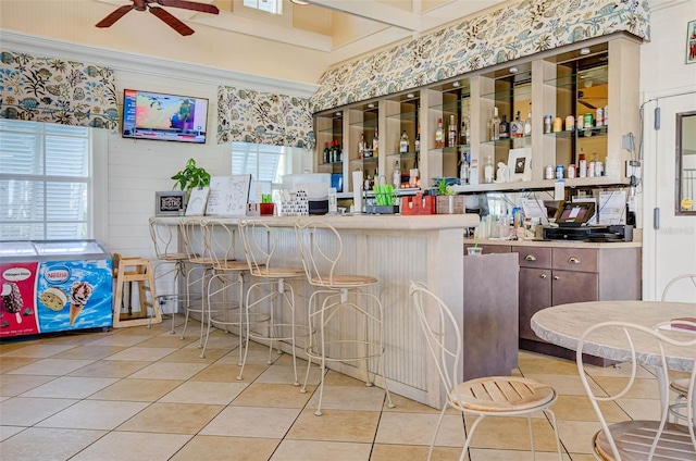 bar featuring light tile patterned flooring and ceiling fan