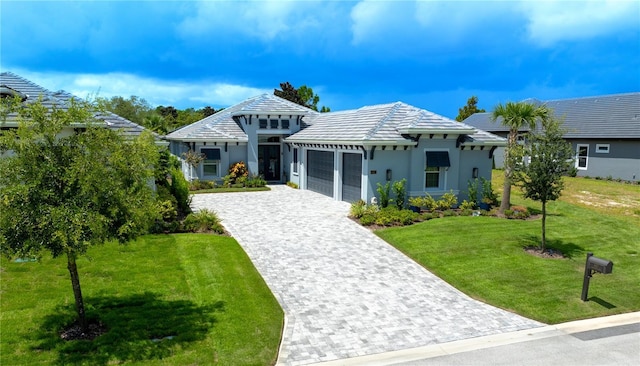 view of front of house with stucco siding, an attached garage, decorative driveway, and a front lawn