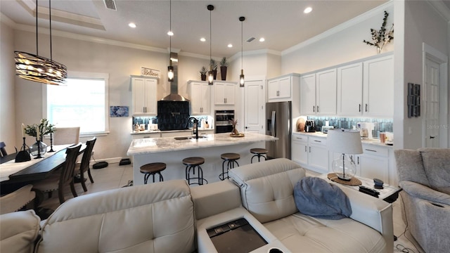 living room featuring crown molding, a chandelier, light tile patterned floors, and sink