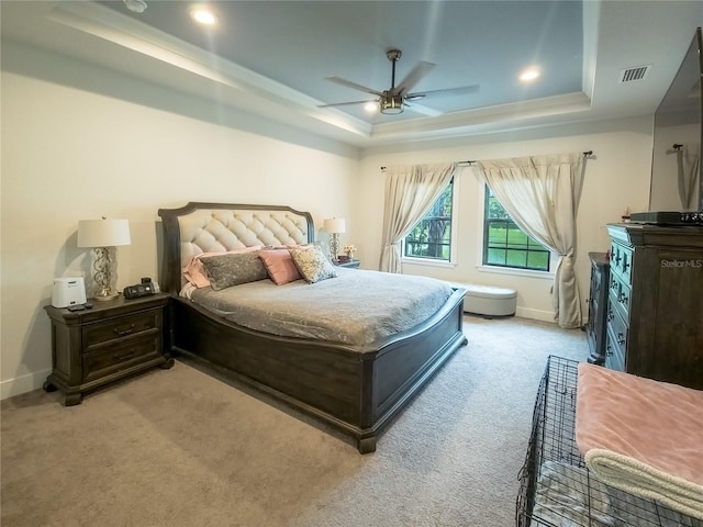 bedroom featuring light colored carpet, ceiling fan, and a tray ceiling