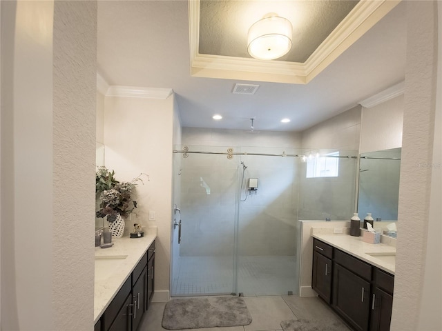 full bathroom with two vanities, a shower stall, visible vents, and ornamental molding