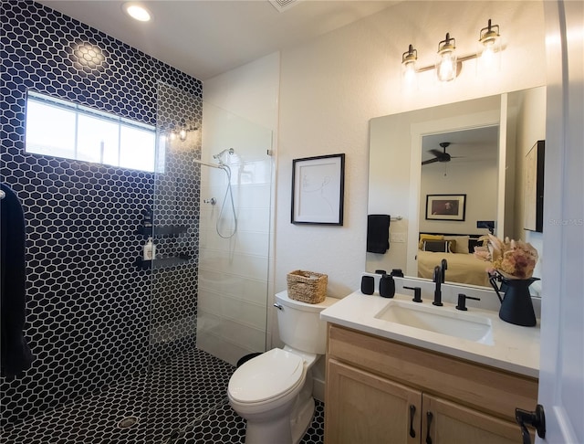 bathroom featuring vanity, toilet, ceiling fan, and walk in shower