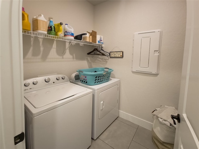 clothes washing area with electric panel, baseboards, separate washer and dryer, laundry area, and light tile patterned floors