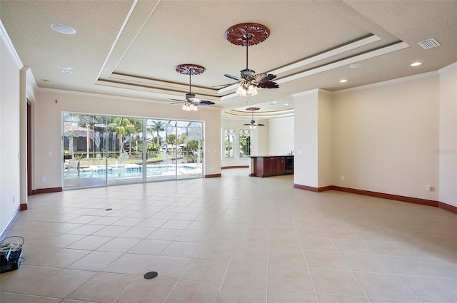 empty room with ceiling fan, a raised ceiling, and crown molding