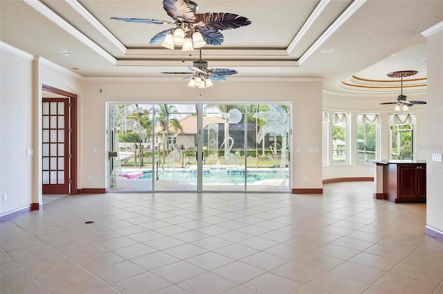 interior space with a tray ceiling, plenty of natural light, and crown molding