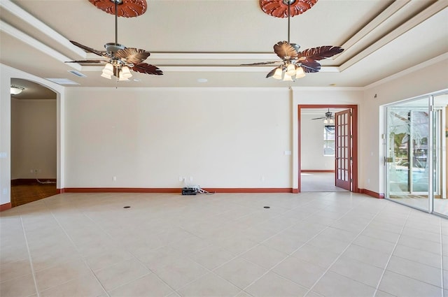 tiled spare room with ceiling fan, a raised ceiling, and ornamental molding