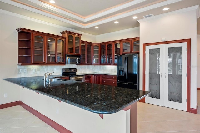 kitchen with dark stone countertops, crown molding, kitchen peninsula, appliances with stainless steel finishes, and light tile patterned flooring