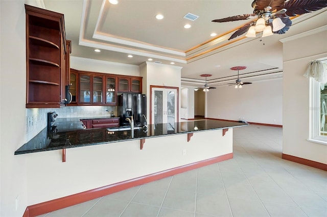 kitchen featuring appliances with stainless steel finishes, ceiling fan, a raised ceiling, and kitchen peninsula