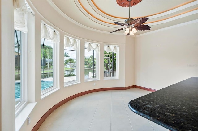 tiled dining space with ornamental molding, a tray ceiling, and ceiling fan