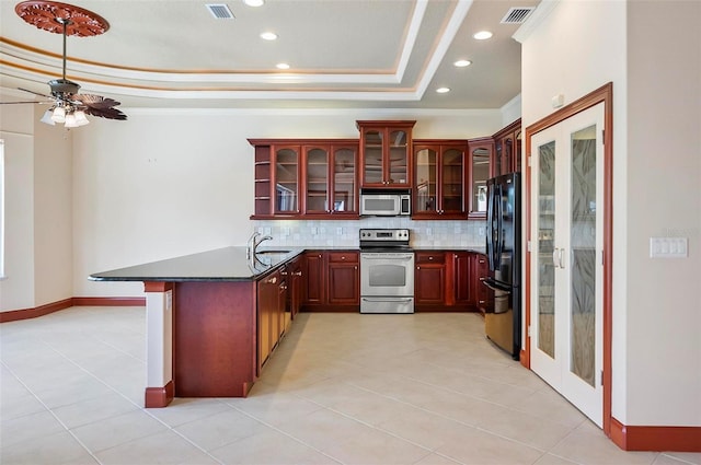 kitchen featuring crown molding, stainless steel appliances, kitchen peninsula, ceiling fan, and tasteful backsplash