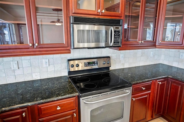 kitchen with backsplash, ceiling fan, dark stone countertops, and appliances with stainless steel finishes