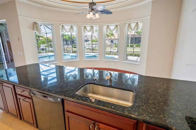 kitchen with plenty of natural light, crown molding, dark stone counters, and stainless steel dishwasher