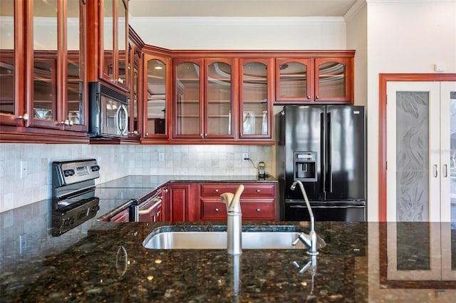 kitchen with crown molding, black appliances, decorative backsplash, and dark stone counters