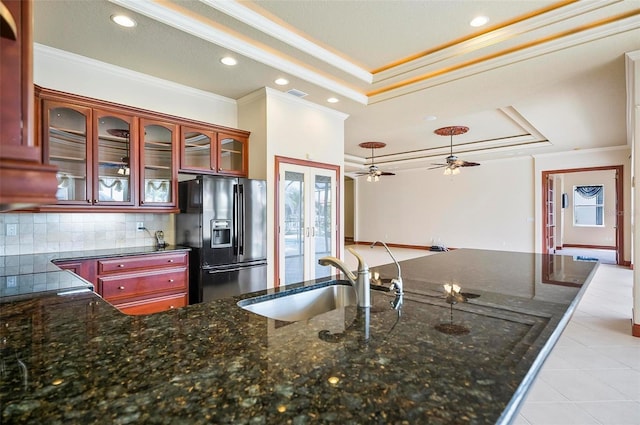 kitchen with dark stone countertops, french doors, sink, black fridge with ice dispenser, and a tray ceiling