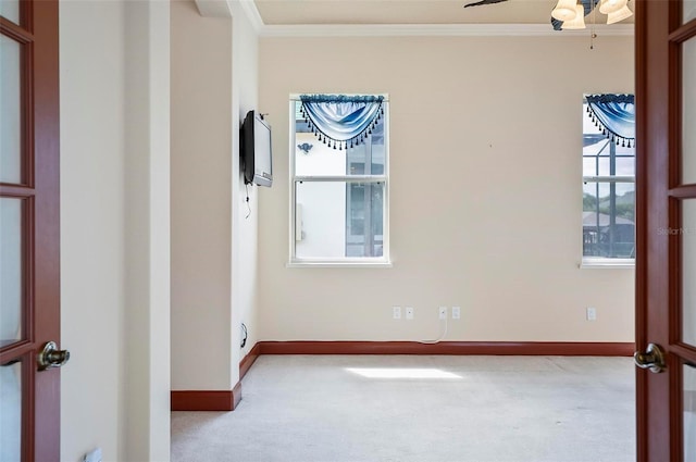 carpeted empty room with crown molding and ceiling fan