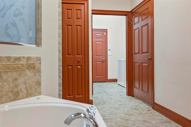 bathroom with a bathing tub and washer / clothes dryer