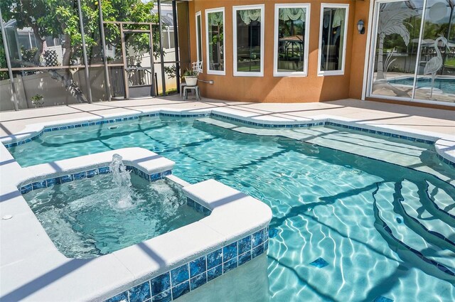 view of pool with pool water feature, a lanai, and an in ground hot tub