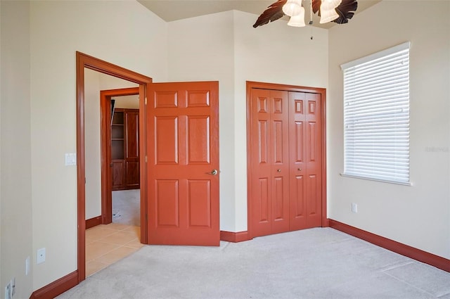 bedroom with multiple windows, ceiling fan, light colored carpet, and a closet