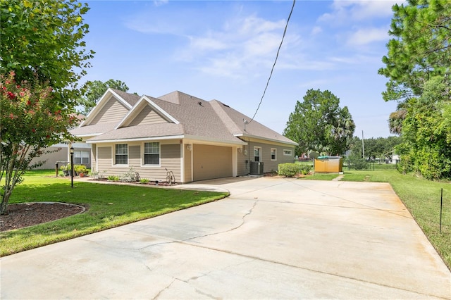 view of front of property with a garage, central AC unit, and a front lawn