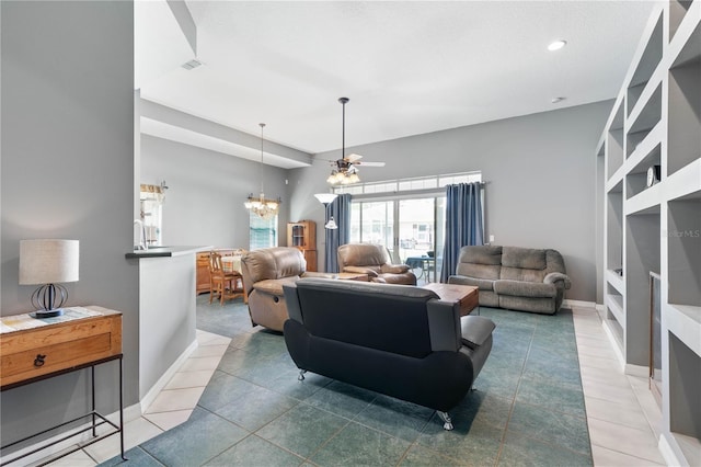 tiled living room featuring ceiling fan with notable chandelier