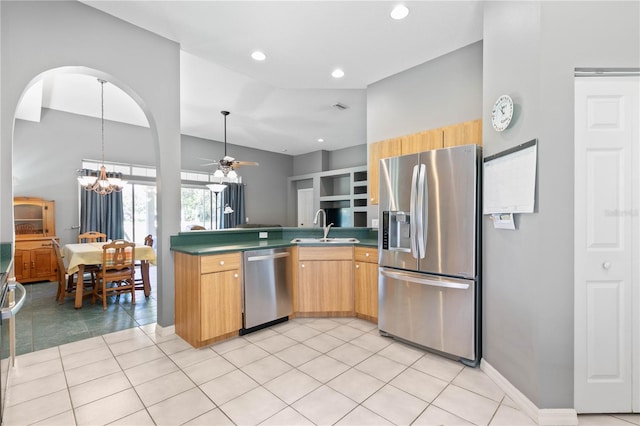 kitchen with ceiling fan with notable chandelier, appliances with stainless steel finishes, sink, kitchen peninsula, and light tile patterned flooring